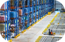Luchtfoto van een modern magazijn met georganiseerde opslagrekken en logistieke apparatuur, die industriële voorraadbeheer en supply chain-operaties benadrukt.